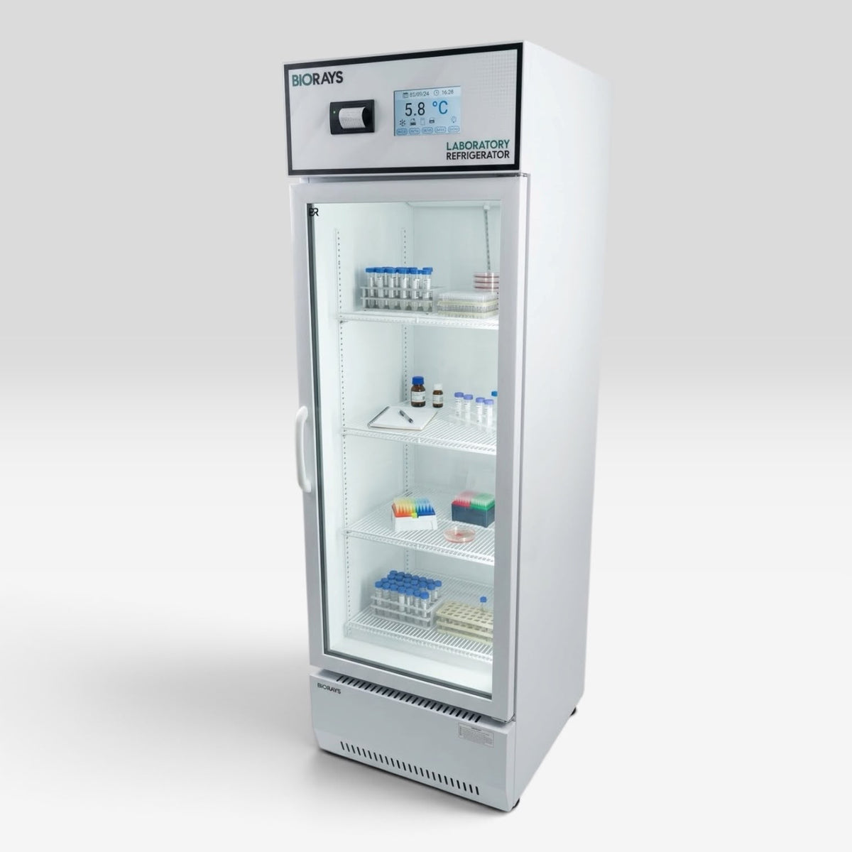 A white laboratory refrigerator with a glass door, interior shelves, and a digital temperature display on the top panel, shown on a light gray studio background.